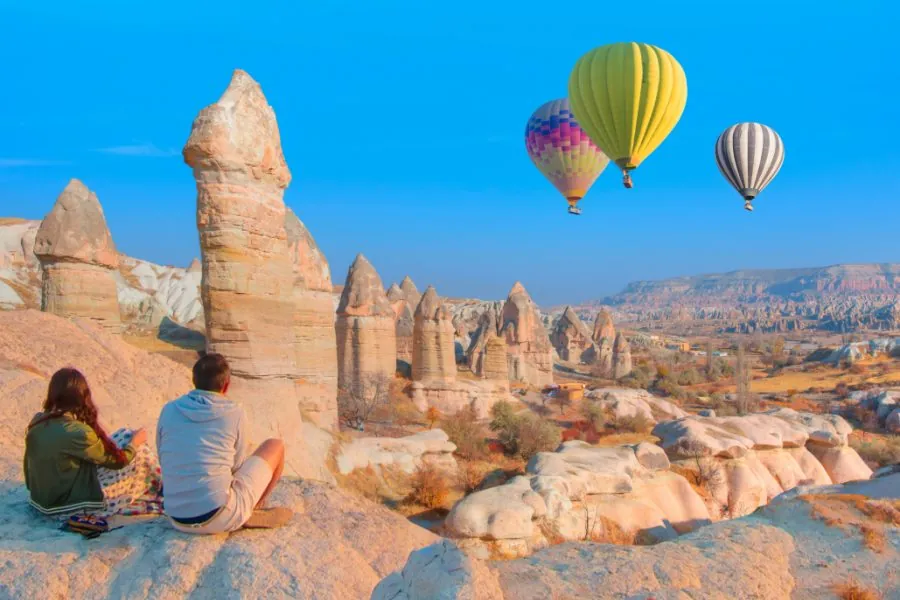Love Valley in Cappadocia, Turkey – panoramic view with hot air balloons floating over unique rock formations