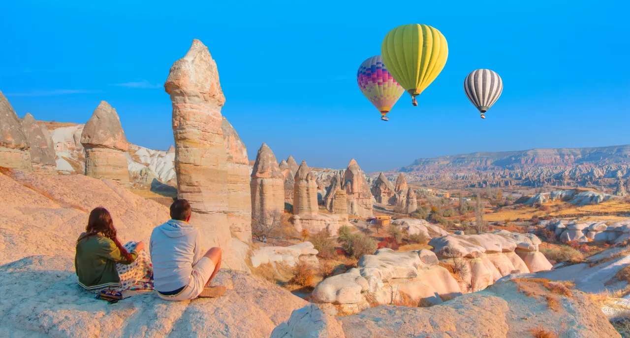 Love Valley in Cappadocia, Turkey – panoramic view with hot air balloons floating over unique rock formations
